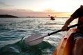 Rear view of kayaker man paddle kayak at sunset sea. Kayaking, canoeing, paddling Royalty Free Stock Photo