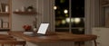 Rear view of a laptop mockup on a wooden dining table in a minimal kitchen at night Royalty Free Stock Photo