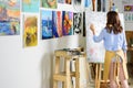 rear view of left-handed female artist painting on canvas Royalty Free Stock Photo