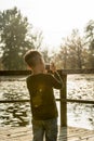 Little boy photographing nature with a compact camera outdoors a