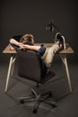 rear view of little boy resting with legs on table with laptop apple and lamp on grey