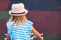 Rear view of little child in summer hat riding bike outdoors in city park. Cute adorable little blond girl from behind Royalty Free Stock Photo