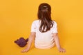 Rear view of little fair haired child sitting on the floor, putting hands aback, being punished, spending time alone, having brown Royalty Free Stock Photo