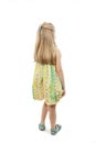 Rear view of little girl in floral dress looking at wall Royalty Free Stock Photo