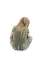 Rear view of little girl sitting on floor looking down. Royalty Free Stock Photo