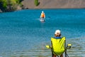 Rear view, a little girl, a teenager, a child, sitting on a camping tourist chair Royalty Free Stock Photo