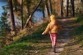 Rear view of little girl in warm clothes that walks on footpath in forest Royalty Free Stock Photo