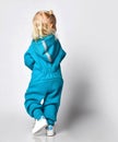 Rear view of a little preschooler girl in a warm blue sports jumpsuit with a hood. Royalty Free Stock Photo