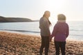 Rear View Of Loving Retired Couple Holding Hands Standing By Shore On Winter Beach Vacation Royalty Free Stock Photo