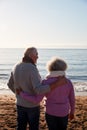 Rear View Of Loving Retired Couple Hugging Standing Looking Out To Sea On Winter Beach Vacation Royalty Free Stock Photo