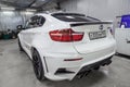 Rear view of luxury very expensive new white BMW X6 M Lumma CLR tuning car stands in the washing box waiting for repair in auto