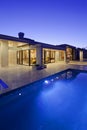 Rear view of luxury villa at night time with swimming pool Royalty Free Stock Photo