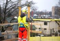 Rear view of male builder construction worker with spirit level on building site wearing hard hat Royalty Free Stock Photo