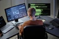 Back of Male Computer Programmer Working at Desk Looking at Screens with Code in Office