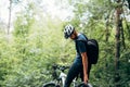 Rear view of male cyclist cycling on mountain road on a sunny day. Professional cyclist riding a bike in the forest outdoor Royalty Free Stock Photo