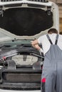 Rear view of male engineer repairing car in automobile repair shop Royalty Free Stock Photo