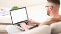 Male freelancer working with document online while sitting on sofa at home