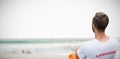 Composite image of rear view of male lifeguard sitting on chair Royalty Free Stock Photo