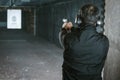 rear view of man aiming gun at target Royalty Free Stock Photo