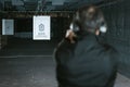 rear view of man aiming gun at target in shooting range Royalty Free Stock Photo