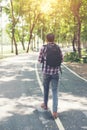 Rear view of man with backpack walking on the side road, Time go