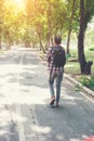 Rear view of man with backpack walking on the side road, Time go