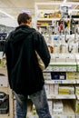 Rear view of man buying shopping for faucets in DIY store