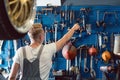 Rear view of a man choosing an useful tool during work in a repair shop