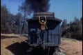 Rear view of man climbing up moving 1860s steam train