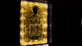Rear view of a man coming close to the sacred golden icon under the protective glass. Concept. Interior of the orthodox