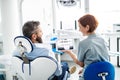 Rear view of man and dentist in dental surgery, annual check-up. Royalty Free Stock Photo