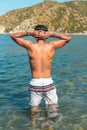 Rear view of man with his hands on his head on the beach. Man on the beach with his hands on his head, back view of the boy, Royalty Free Stock Photo