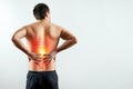 Rear view, the man holds his hands behind his back, pain in the back, pain in the spine, highlighted in red. Royalty Free Stock Photo