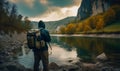Rear view of a man in hoodie with a backpack. Tourist watching a peaceful river flowing among the mountains and woods. Generative