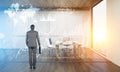 Rear view of a man looking at holograms on conference room wall Royalty Free Stock Photo