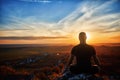 Rear view of the man meditating yoga in lotus pose on the rock at sunset. Royalty Free Stock Photo