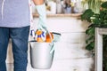 Rear view of a man with protective gloves doing housework. Basket with cleaning products Royalty Free Stock Photo