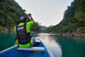 Rear view of man in raincoat and vest rowing in canoe. Active, adventure, outdoors, in tamul riverTAMUL, SAN LUIS POTOSI MEXICO -