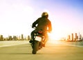 rear view of man riding motorcycle on urban traffic road for people leisure traveling theme