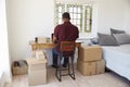 Rear View Of Man Running Business From Home Dispatching Goods