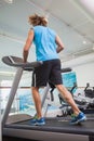 Rear view of man running on treadmill in gym Royalty Free Stock Photo