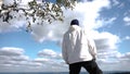 Rear view of man standing against sky and glancing at horizon. Footage. Lonely man in harmony with nature. Concept of Royalty Free Stock Photo