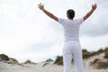 Rear view of man standing with arms outstretched on beach Royalty Free Stock Photo