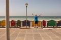 Rear view of man standing with arms outstretched on a promenade at beach Royalty Free Stock Photo