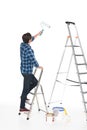 rear view of man standing on ladder with roller paint Royalty Free Stock Photo