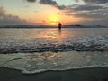 Rear View Of Man Standing In Sea Against Sky During Sunset Royalty Free Stock Photo