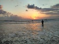 Rear View Of Man Standing In Sea Against Sky During Sunset Royalty Free Stock Photo