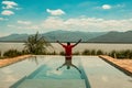 Rear view a man standing in swimming pool against the background of Lake Jipe in Kenya/Tanzania border in Tsavo