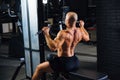 Rear view, a man trains in the gym, trains his back. Athlete`s muscular back