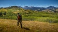 Rear view of a man walking in the fields of Montana with mountains in the background Royalty Free Stock Photo